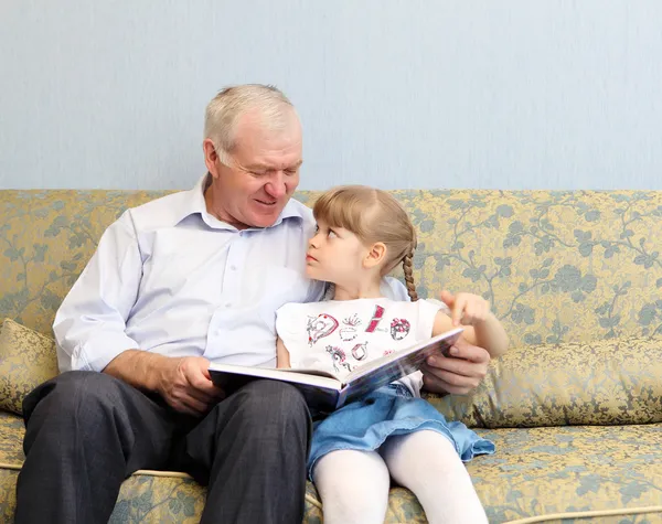 Grandfather and granddaughter reading book — Stock Photo, Image