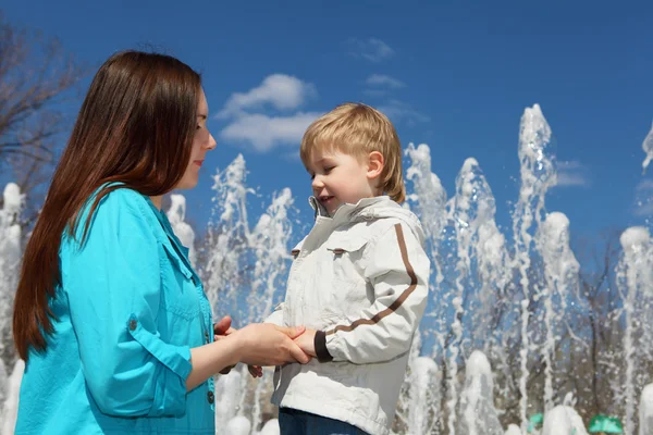 Ung pojke och hans mor promenader i parken — Stockfoto