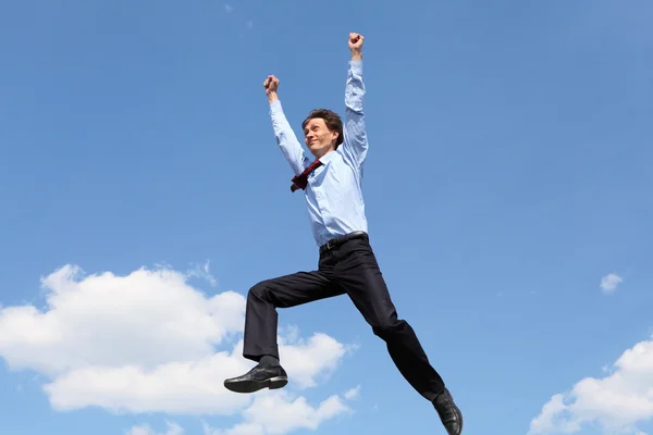 Springen jonge zakenman in een blauw shirt — Stockfoto