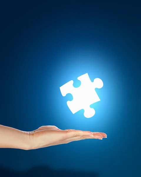 Human hand with a piece of puzzle — Stock Photo, Image