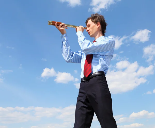 Young business man looks through a telescope — Stock Photo, Image