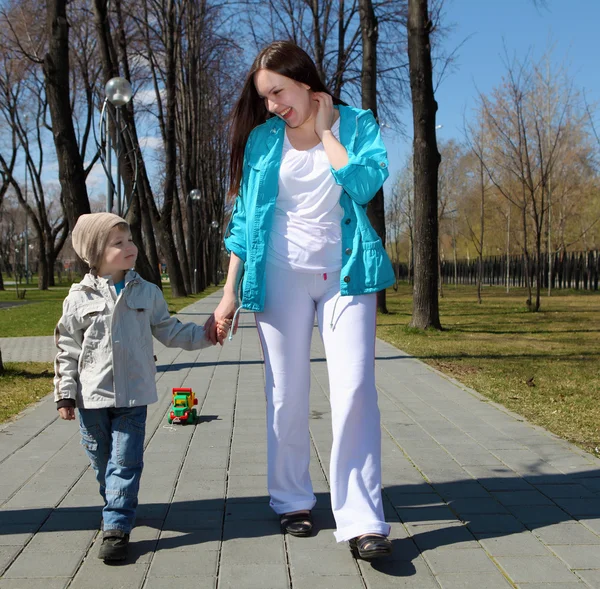 Мальчик и его мать гуляют по парку — стоковое фото