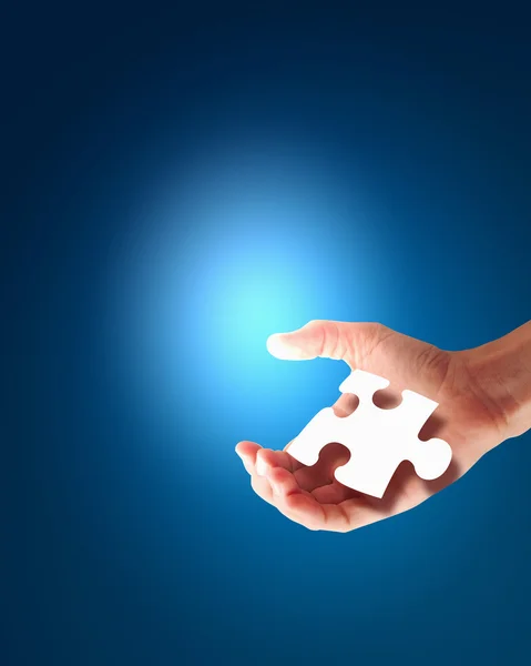 Lidská ruka s kouskem puzzle — Stock fotografie