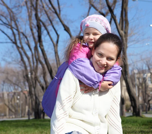 Kleines Mädchen mit Mutter im Frühlingspark — Stockfoto
