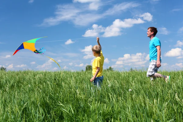 Vader en zoon in de zomer met kite — Stockfoto