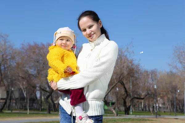 Маленька дівчинка з матір'ю у весняному парку — стокове фото
