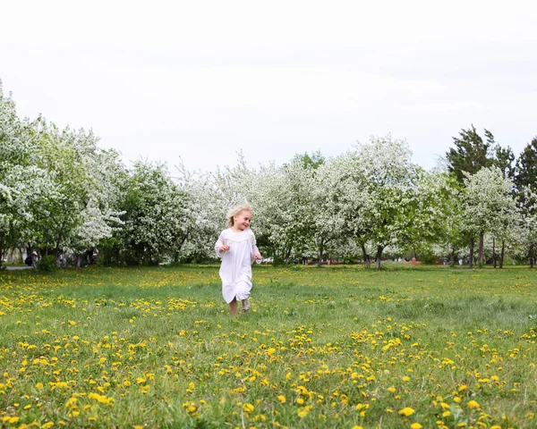 Pieni tyttö kevätpuistossa — kuvapankkivalokuva