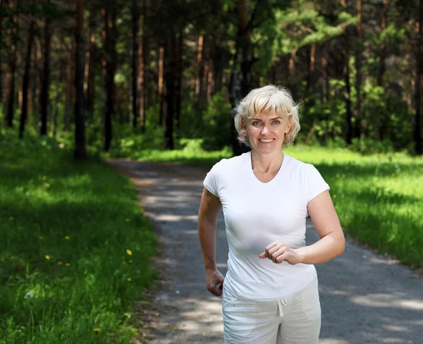Ältere Frau läuft gerne im Park — Stockfoto