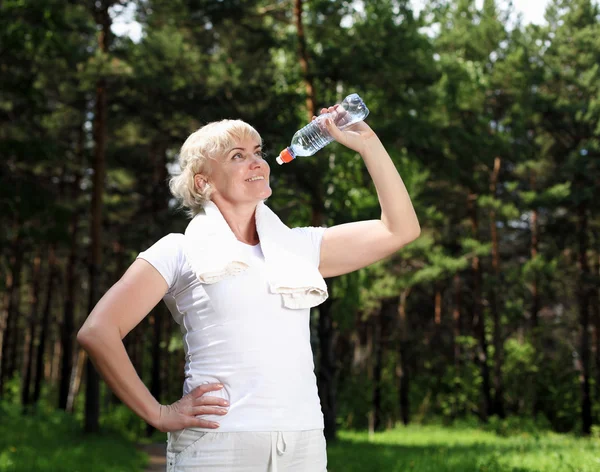 Mujer mayor después de hacer ejercicio en el bosque —  Fotos de Stock