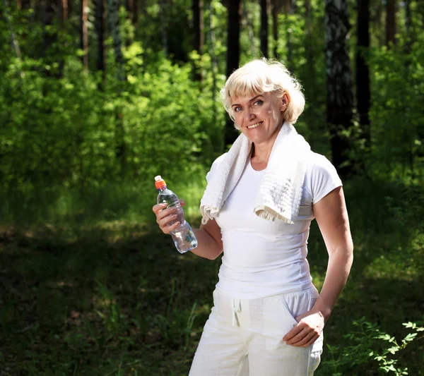Пожилая женщина после тренировки в лесу — стоковое фото