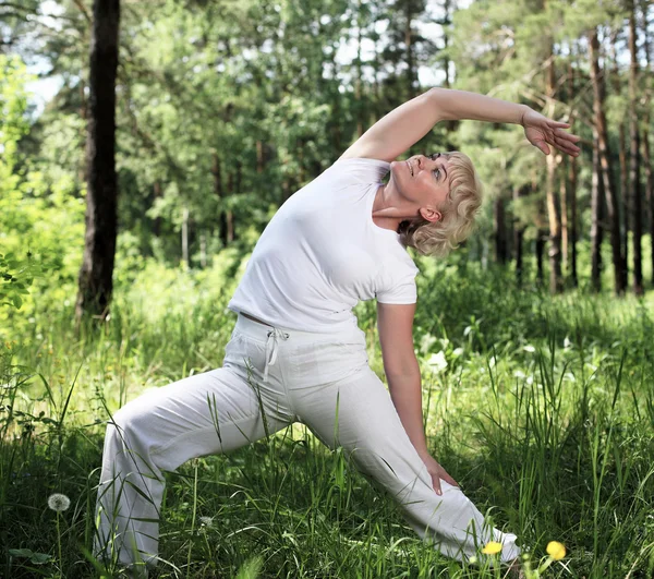 Una donna anziana pratica yoga — Foto Stock