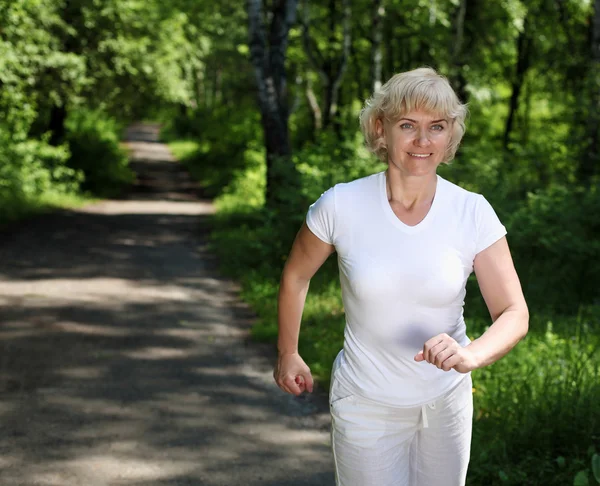 Elderly woman likes to run in the park — Stock Photo, Image