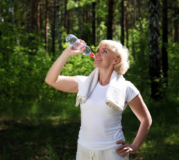 Starší žena po cvičení v lese — Stock fotografie