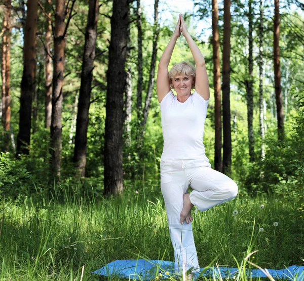 Egy idős nő jógázik. — Stock Fotó