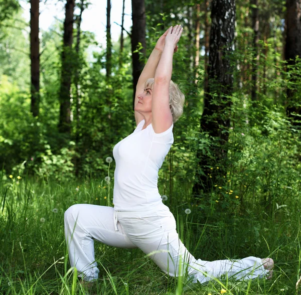Eine ältere Frau praktiziert Yoga — Stockfoto