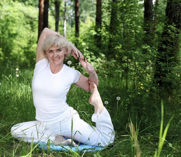 Egy idős nő jógázik. — Stock Fotó