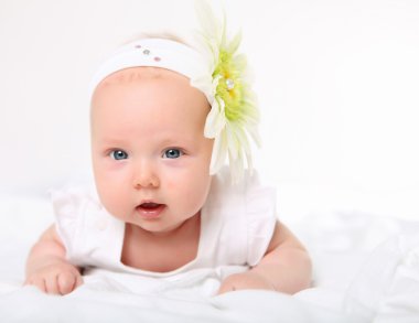 Portrait of a baby girl with a flower on her head clipart