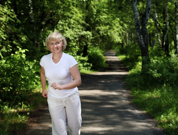 Пожилая женщина любит бегать по парку — стоковое фото