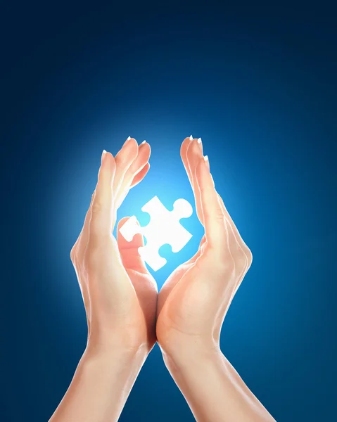 Menselijke hand met een stukje van de puzzel — Stockfoto