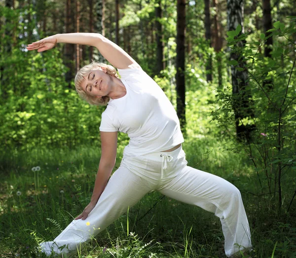Uma mulher idosa pratica ioga — Fotografia de Stock