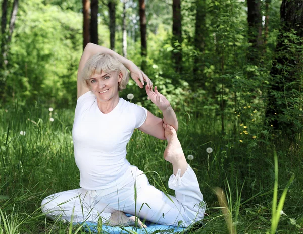 Una donna anziana pratica yoga — Foto Stock