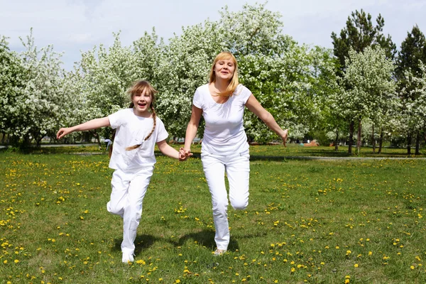 Dívka s matkou v parku na jaře — Stock fotografie