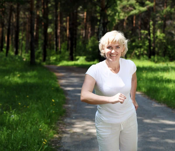 Ältere Frau läuft gerne im Park — Stockfoto