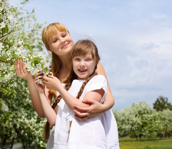 Menina com a mãe no parque de primavera — Fotografia de Stock