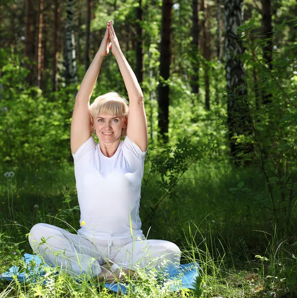 Starší žena cvičí jógu — Stock fotografie