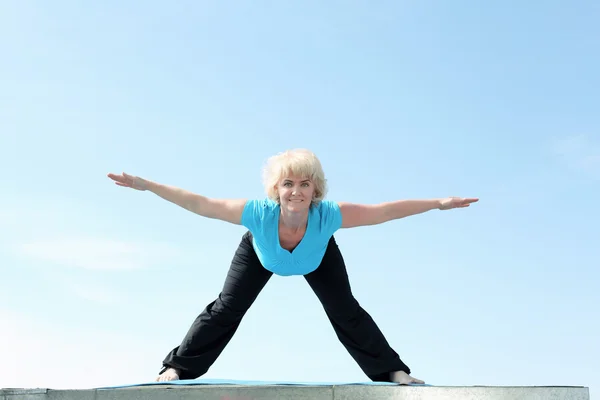 Retrato de uma mulher idosa fazendo ioga — Fotografia de Stock