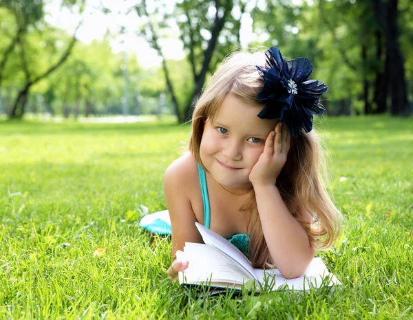 Olvasson egy könyvet a park kislány portréja — Stock Fotó