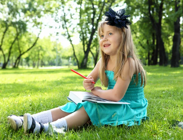 Olvasson egy könyvet a park kislány portréja — Stock Fotó