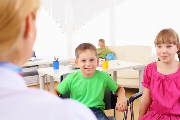 Dzieci w wieku szkolnym słuchać ich nauczyciel — Zdjęcie stockowe