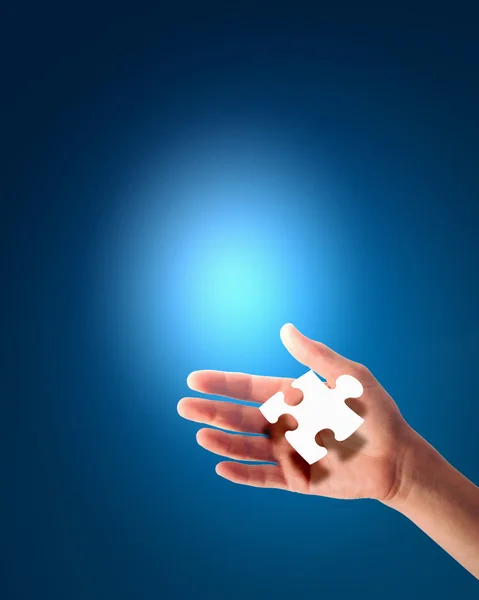 Human hand with a piece of puzzle — Stock Photo, Image
