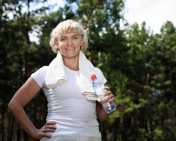 Mujer mayor después de hacer ejercicio en el bosque — Foto de Stock