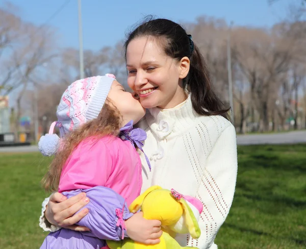 Маленька дівчинка з матір'ю у весняному парку — стокове фото