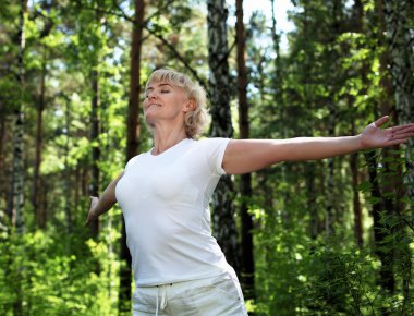 An elderly woman practices yoga clipart