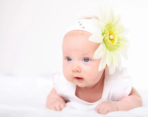 Retrato de una niña con una flor en la cabeza — Foto de Stock