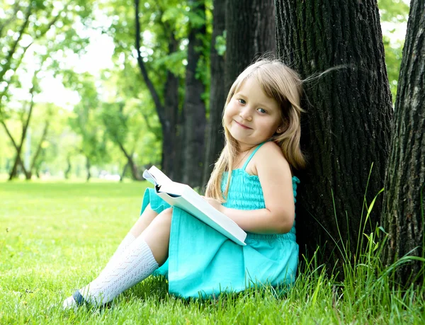 Portret van meisje het lezen van een boek in het park — Stockfoto