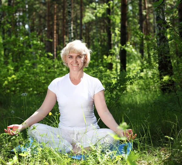 Eine ältere Frau praktiziert Yoga — Stockfoto