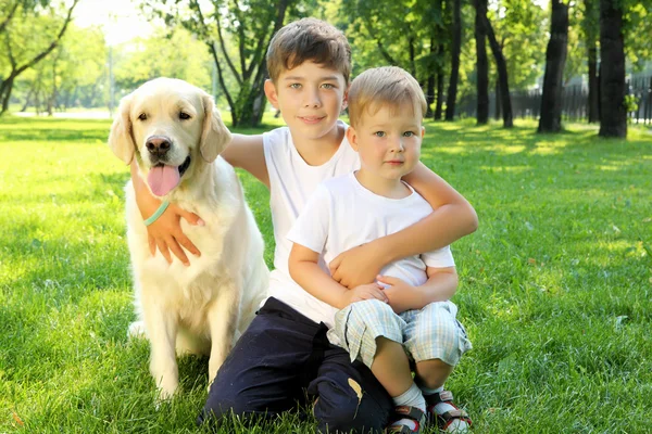 Petit garçon dans le parc avec un chien — Photo