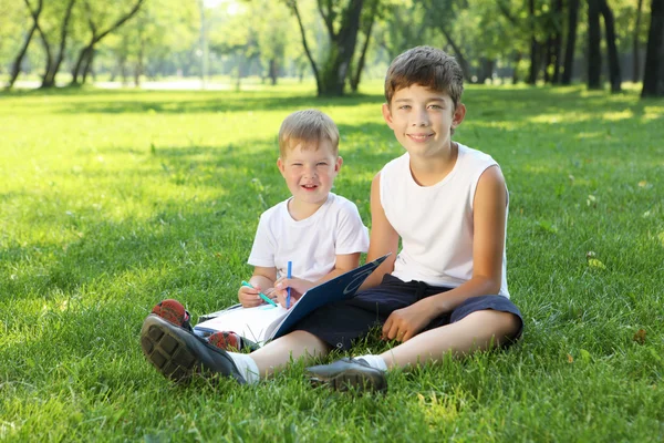 Barn i parken läser en bok — Stockfoto