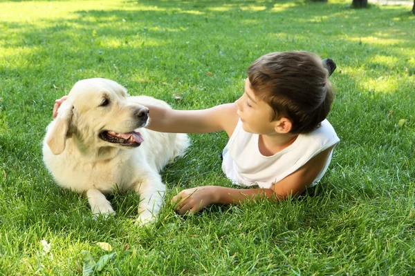 Tennager pojke i parken med en hund — Stockfoto