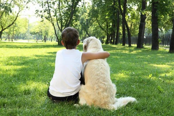 Tennager garçon dans le parc avec un chien — Photo
