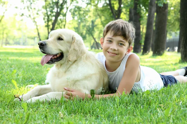 Menino no parque com um cão — Fotografia de Stock