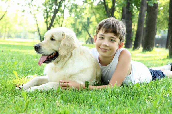 Menino no parque com um cão — Fotografia de Stock