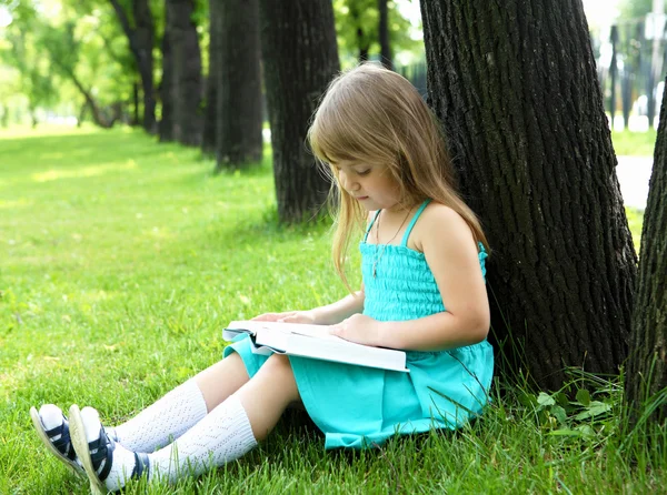Portret dziewczynki, czytanie książki w parku — Zdjęcie stockowe