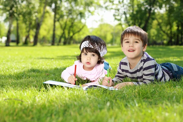 Дети в парке читают книгу — стоковое фото