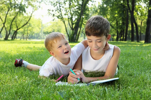 Niños en el parque leyendo un libro —  Fotos de Stock