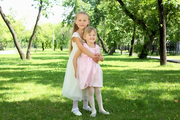 Two little sisters in the summer park — Stock Photo, Image